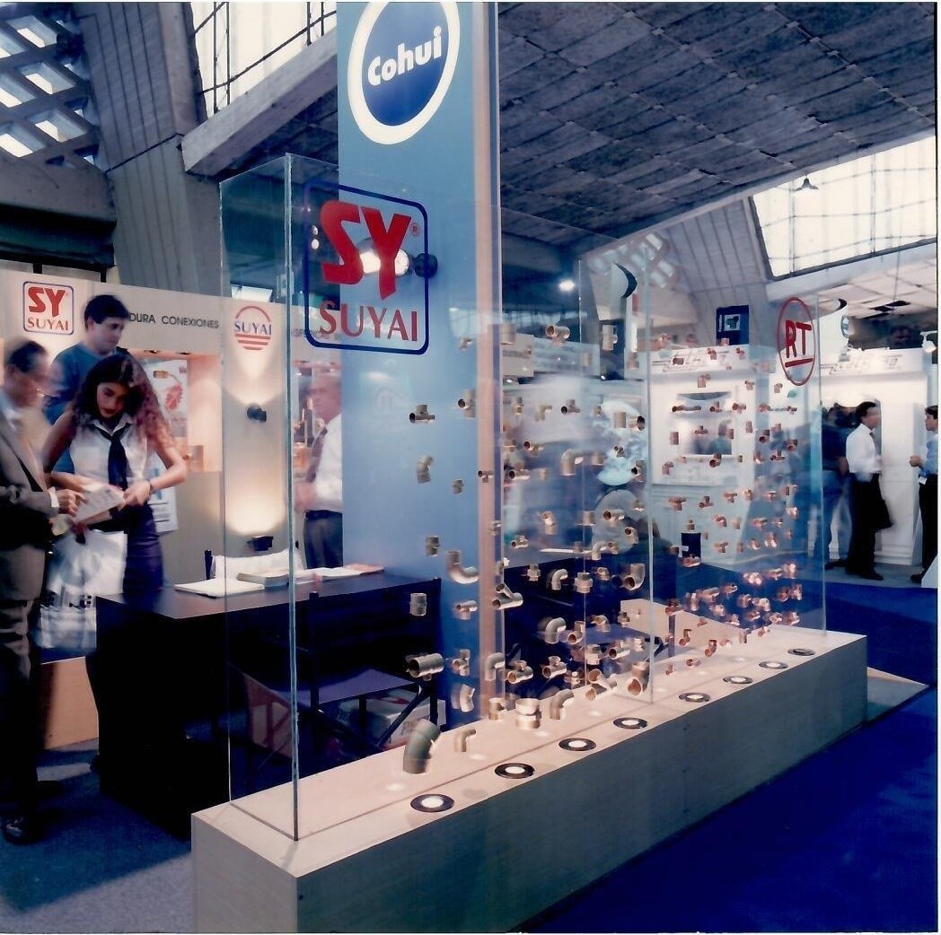 Stand de Cohui · Suyai en Expo Sanitarios — vitrina con conexiones de bronce